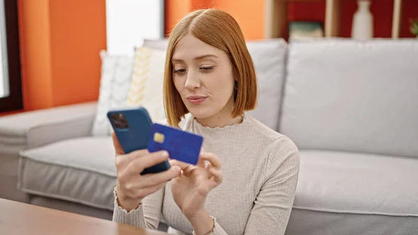 Akıllı Telefon Kredi Kartıyla Alışveriş Yapan Genç Sarışın Kadın Evde — Stok fotoğraf