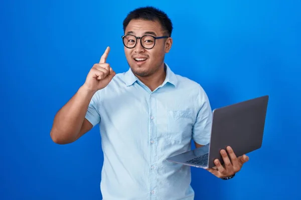 Chino Joven Usando Computadora Portátil Apuntando Con Dedo Hacia Arriba —  Fotos de Stock