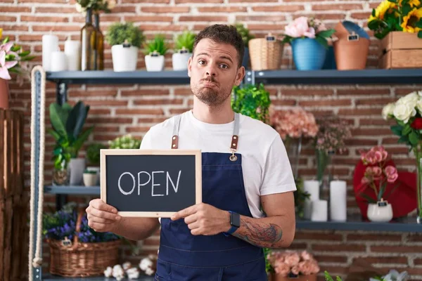 stock image Young hispanic man working at florist holding open sign depressed and worry for distress, crying angry and afraid. sad expression. 