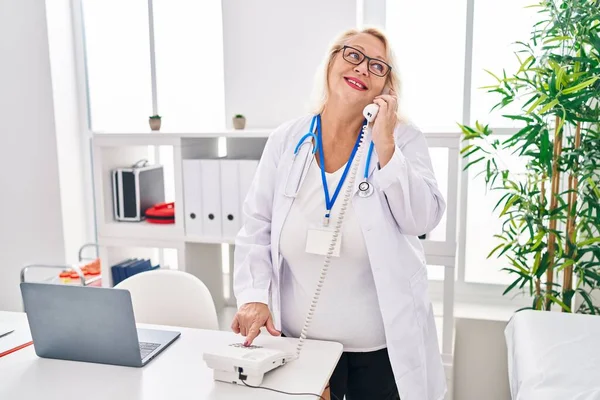 Středního Věku Blondýny Žena Nosí Lékařskou Uniformu Mluví Telefonu Klinice — Stock fotografie