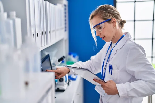 Young Blonde Woman Scientist Using Computer Reading Document Laboratory — Stock Photo, Image