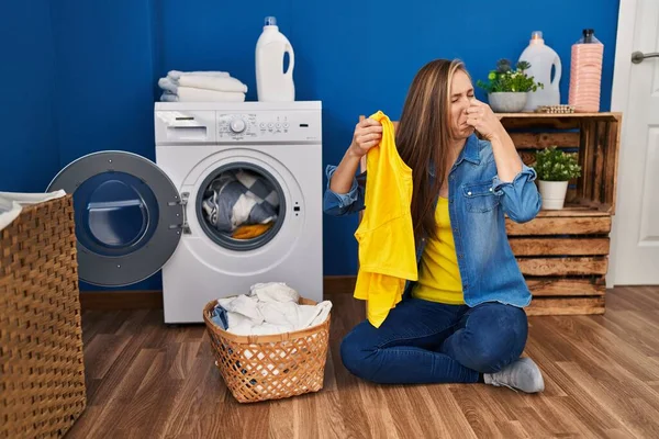 Young Blonde Woman Smelling Dirty Clothes Laundry Room — Stock Photo, Image