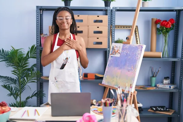 年轻的非洲裔美国人 画室里的辫子画在画布上 双手放在胸前 闭着眼睛 脸上挂着感恩的手势 微笑着 健康概念 — 图库照片