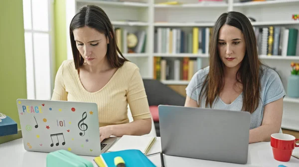 Dwie Kobiety Siedzące Stole Studiujące Laptopie Uniwersytecie Bibliotecznym — Zdjęcie stockowe