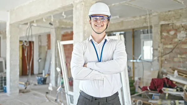 建設現場で腕を組んで自信を持って立って笑顔若いヒスパニック男建築家 — ストック写真