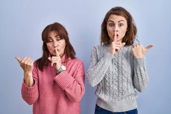 Mother Daughter Standing Blue Background Asking Quiet Finger Lips Pointing — Stock Photo, Image