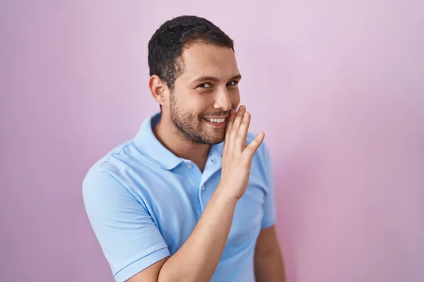 Hispanic Man Står Över Rosa Bakgrund Hand Mun Berättar Hemliga — Stockfoto