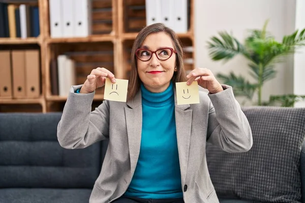 Orta yaşlı İspanyol kadın depresyonda. Mutluluk kağıdını tutuyor. Gülümsüyor ve düşünüyor.. 