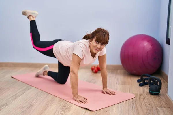 Orta Yaşlı Kadın Gülümsüyor Spor Merkezinde Kendine Güvenen Bacak Egzersizi — Stok fotoğraf