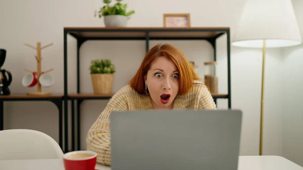 Νεαρή Κοκκινομάλλα Γυναίκα Που Χρησιμοποιεί Φορητό Υπολογιστή Έκφραση Έκπληξη Στο — Φωτογραφία Αρχείου