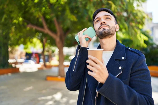 Hombre Hispano Joven Escuchando Mensaje Voz Por Teléfono Inteligente Bebiendo —  Fotos de Stock