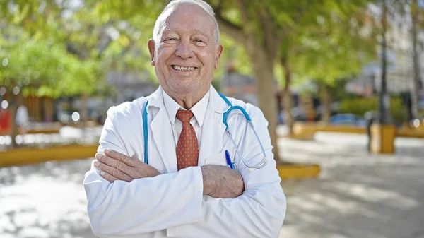 Starší Šedovlasý Muž Lékař Usmívá Sebevědomě Stojí Rukama Zkříženýma Gestem — Stock fotografie
