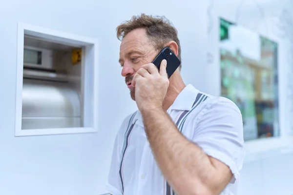 Orta Yaşlı Bir Adam Sokakta Ciddi Bir Ifadeyle Akıllı Telefondan — Stok fotoğraf