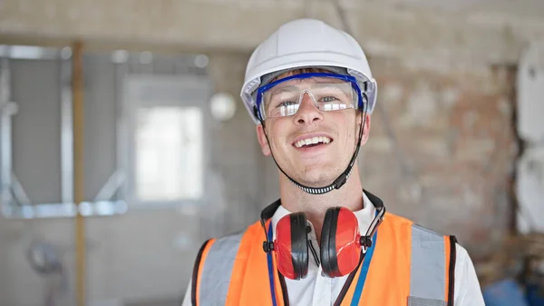 年轻的高加索人建筑师微笑着自信地站在建筑工地 — 图库照片
