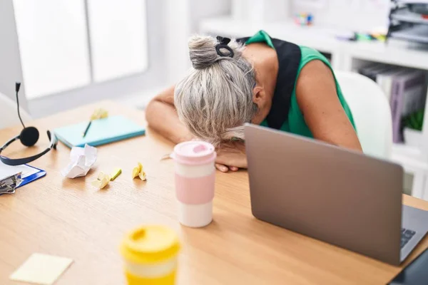 中年白发女商人在办公室使用笔记本电脑感到压力 — 图库照片