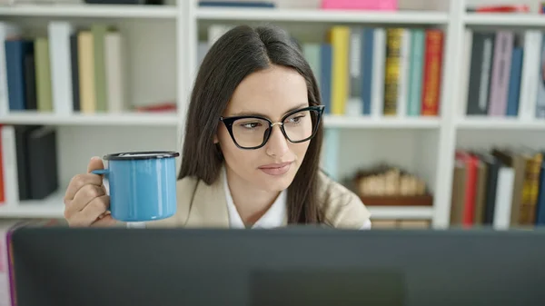 在大学教室用电脑喝咖啡的年轻而漂亮的惊慌失措的女学生 — 图库照片