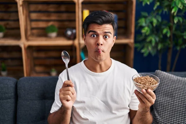 Hombre Hispano Comiendo Cereales Integrales Saludables Con Cuchara Haciendo Cara — Foto de Stock
