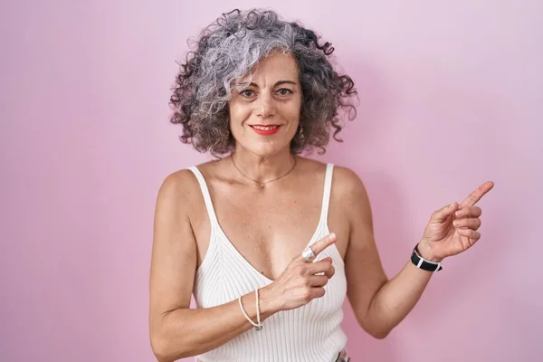 Pembe Arka Planda Gri Saçlı Orta Yaşlı Bir Kadın Gülümsüyor — Stok fotoğraf