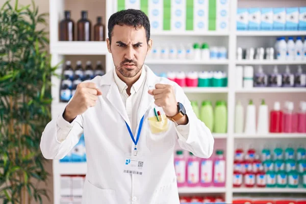 Handsome Hispanic Man Working Pharmacy Drugstore Angry Mad Raising Fists — Stock Photo, Image