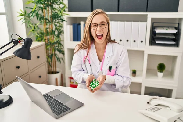 Young Blonde Doctor Woman Holding Pills Winking Looking Camera Sexy — Stock Photo, Image