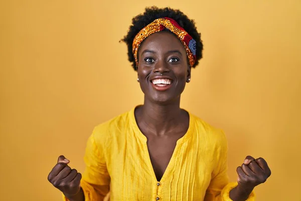 戴着非洲头巾的非洲年轻女子 高举双臂睁大眼睛庆祝胜利 感到惊讶和惊奇 获奖者概念 — 图库照片