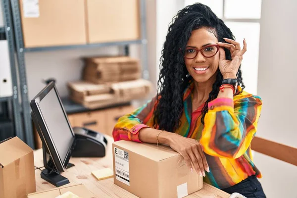 stock image African american woman business worker leaning on package at office