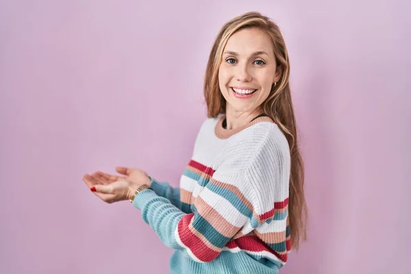 Young Blonde Woman Standing Pink Background Pointing Aside Hands Open — Fotografia de Stock