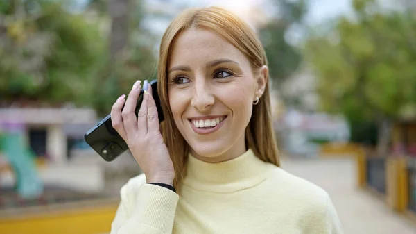 Молодая Блондинка Улыбается Уверенно Слушая Аудиосообщение Смартфона Парке — стоковое фото