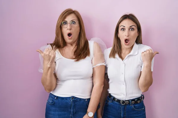 Hispanic Mother Daughter Wearing Casual White Shirt Pink Background Surprised — 스톡 사진