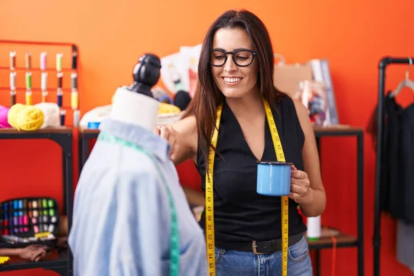 Junge Schöne Hispanische Schneiderin Trinkt Kaffee Rührendes Hemd Auf Schaufensterpuppe — Stockfoto