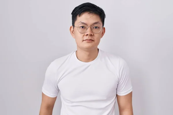 Mladý Asiat Stojící Nad Bílým Pozadím Uvolnil Vážným Výrazem Tváři — Stock fotografie