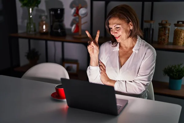 Середньовічна Жінка Використовує Ноутбук Вдома Вночі Посміхаючись Щасливим Обличчям Підморгнутим — стокове фото