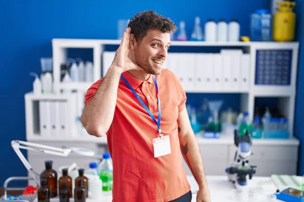 Young Hispanic Man Working Scientist Laboratory Smiling Hand Ear Listening — Stock Photo, Image