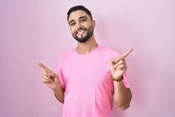 Іспанський Молодий Чоловік Стоїть Над Рожевим Фоном Усміхається Упевненістю Вказуючи — стокове фото