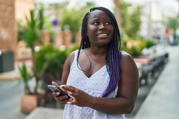 在咖啡店的阳台上 非洲裔美国妇女自信地使用智能手机微笑 — 图库照片