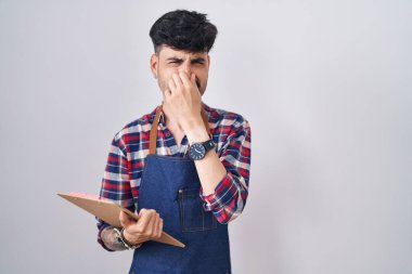 Sakallı, garson önlüğü takan genç bir İspanyol. Elinde bir pano var. Kokuşmuş ve iğrenç bir koku var. Kötü kokuyor. 