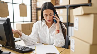 Genç, güzel, İspanyol bir kadın. İşadamı, ofisteki akıllı telefon okuma belgeleriyle konuşuyor.