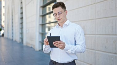 Genç İspanyol iş adamı hastanede dokunmatik kağıda yazı yazıyor.