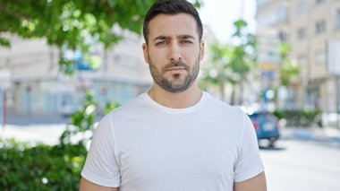 Sokakta ciddi bir ifadeyle duran İspanyol genç adam.