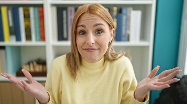 Genç, sarışın bir kız öğrenciyle oturuyor. Üniversite sınıfında nasıl derler bilmiyorum.