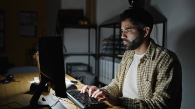 Young hispanic man business worker using computer working at office