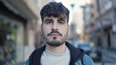 Sokakta ciddi bir ifadeyle duran İspanyol genç adam.