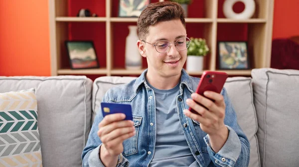 Молодий Іспаномовний Чоловік Купує Смартфоном Кредитною Карткою Сидячи Дивані Вдома — стокове фото