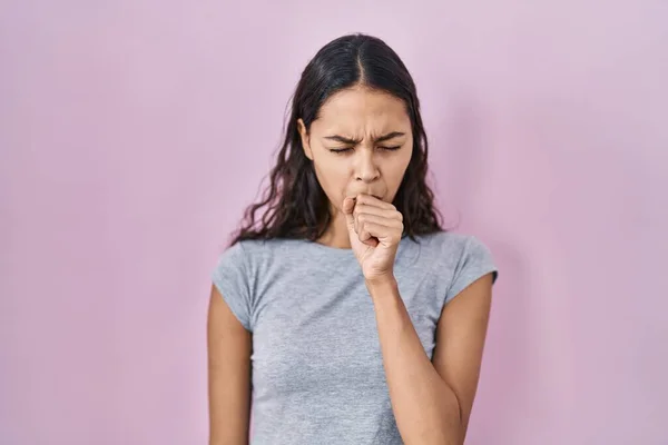 ピンクを背景にカジュアルなTシャツを着た若いブラジル人女性は具合が悪く 風邪や気管支炎の症状として咳をしています ヘルスケアの概念 — ストック写真