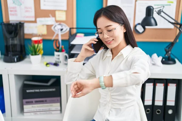 若い中国人女性ビジネスワーカーTalkのスマートフォン見る上のオフィスで — ストック写真