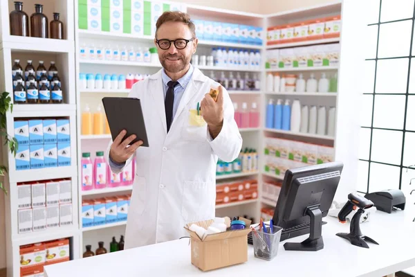 Middle Age Man Pharmacist Using Touchpad Holding Pills Bottle Pharmacy — Stock Photo, Image