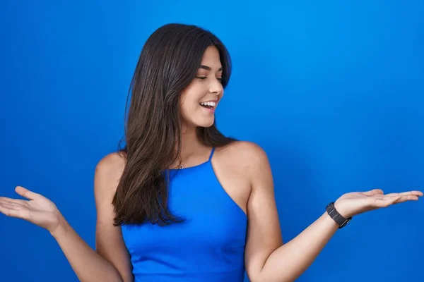 Hispanic Woman Standing Blue Background Smiling Showing Both Hands Open — Stok fotoğraf