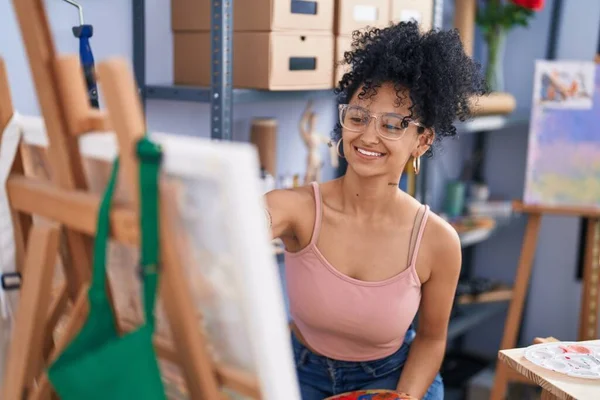 年轻的惊慌失措的女画家带着自信的笑容在艺术工作室里画画 — 图库照片