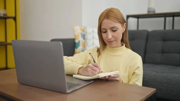 Νεαρή Ξανθιά Γυναίκα Που Χρησιμοποιεί Φορητό Υπολογιστή Γραπτώς Στο Σημειωματάριο — Φωτογραφία Αρχείου
