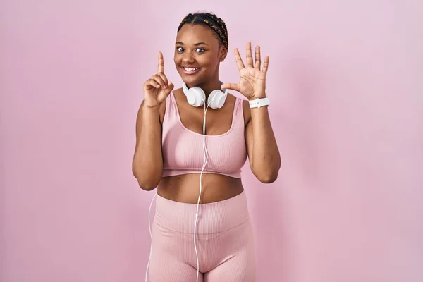 Afroamerikanerin Mit Zöpfen Sportbekleidung Und Kopfhörer Zeigt Mit Finger Nummer — Stockfoto